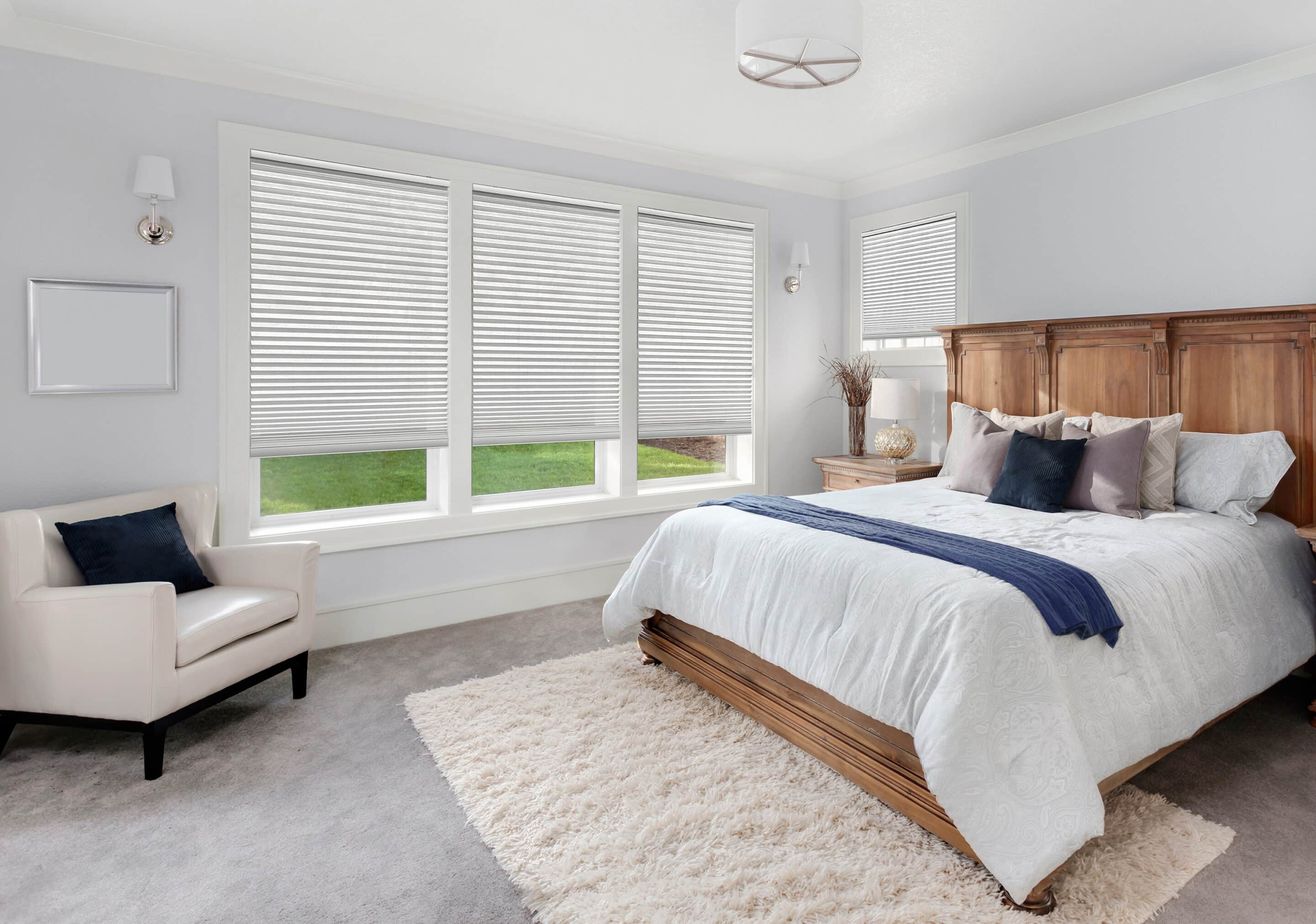 Custom made cellular shades filtering in light into a sleek bedroom.